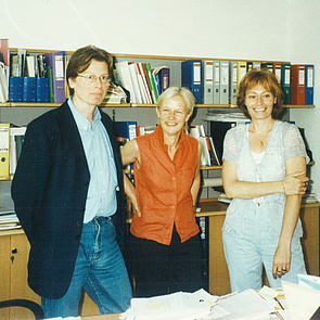 Ein altes Foto von 1997. Damals wurden die ersten Kurse für Menschen mit Behinderung geplant. Es stehen Gerhard Bisovsky, Ilona Weigl und Beatrix Eder-Gregor in einem Büro stehen. Sie lächeln in die Kamera.